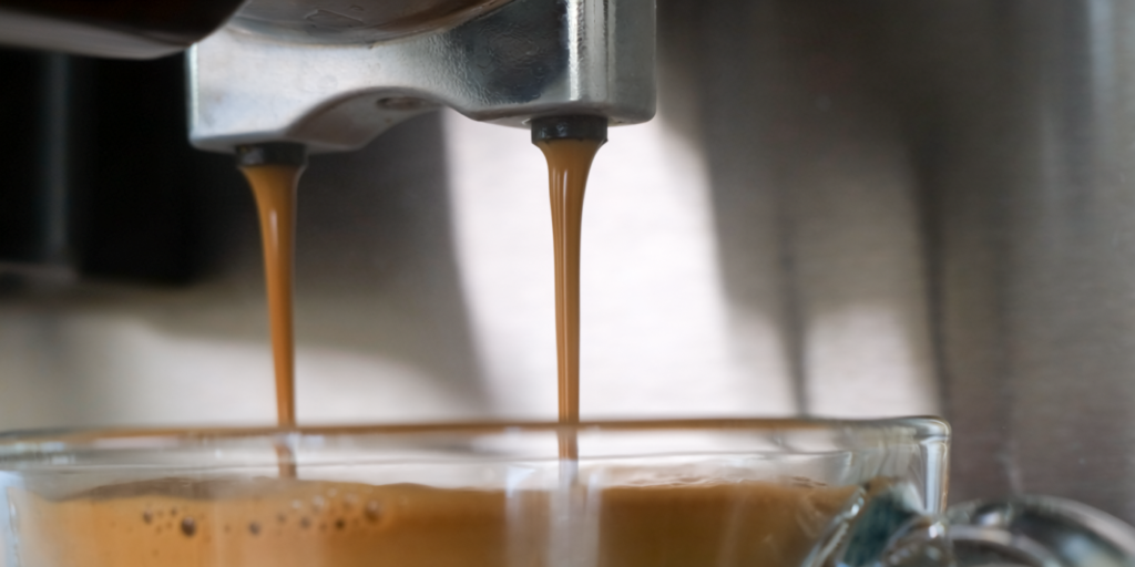 Dòng espresso chảy vào ly từ máy pha cà phê CASO