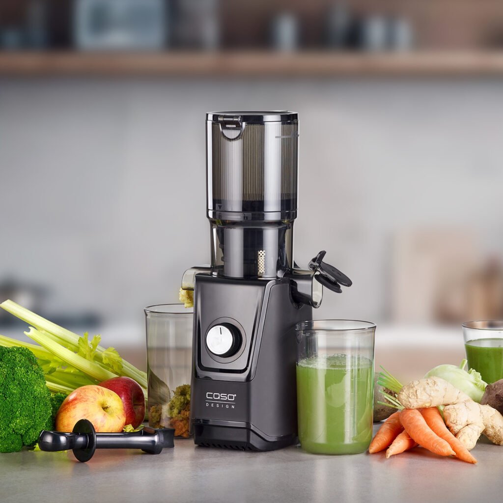 Máy ép chậm CASO JuiceFit cùng ly nước ép và trái cây tươi